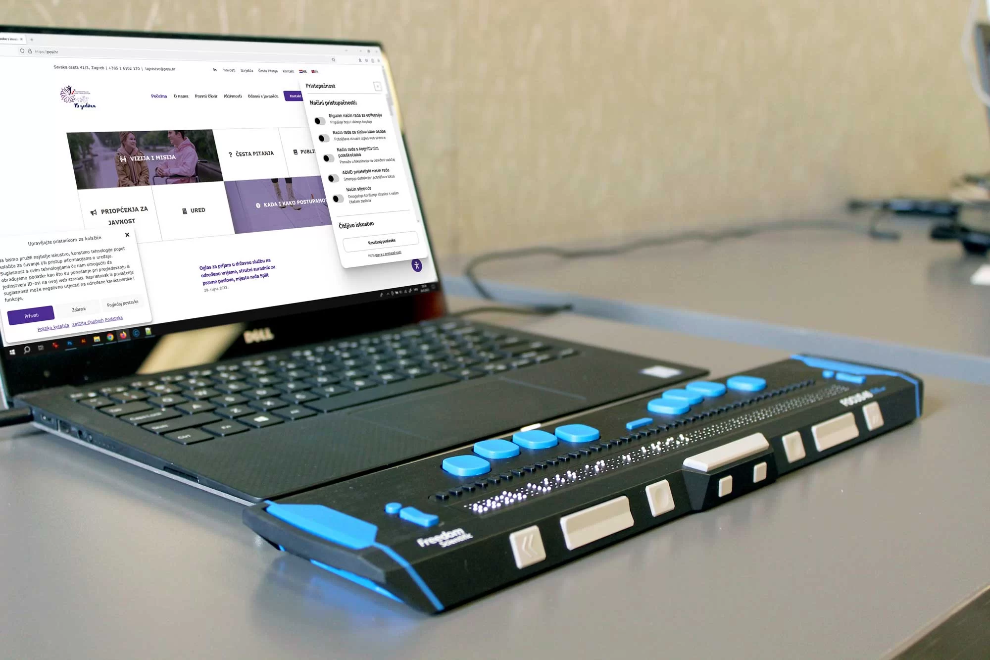 Website of the Ombudsman for Persons with Disabilities displayed on a laptop next to a Braille device, highlighting digital accessibility.